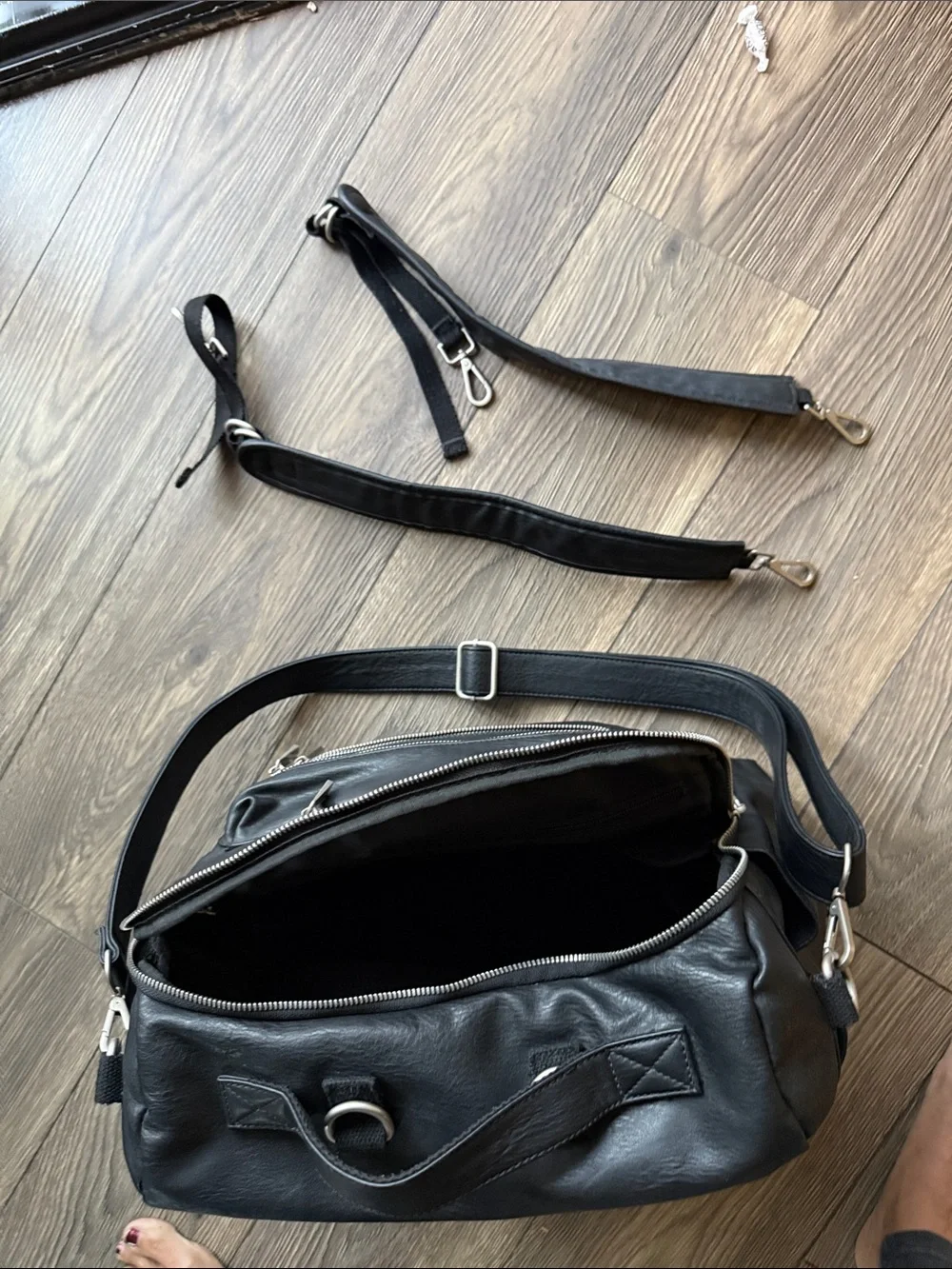 The Honest Company Black Vegan Leather Diaper Bag backpack model cross country